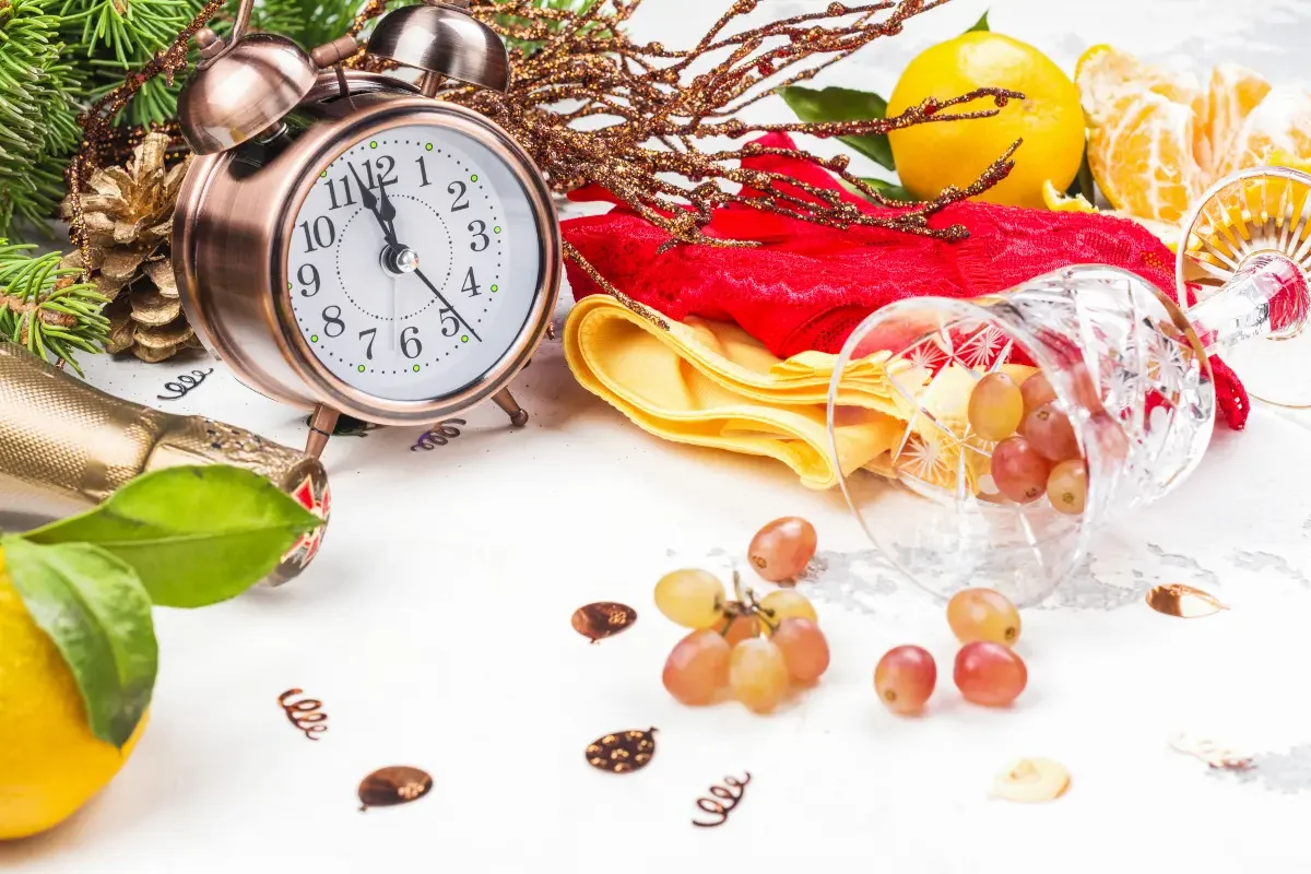 Festive New Year's Eve table with clock, grapes, and citrus